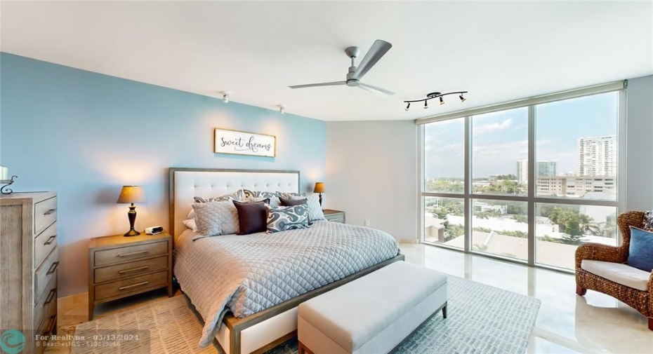 Primary bedroom with floor to ceiling windows with direct ocean views