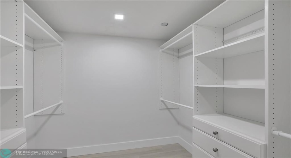 Walk in closet in main bedroom with closet organizer