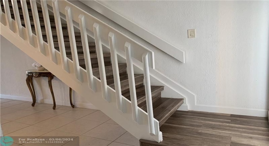 tile in living area. Laminate transition to stairs and upper level.