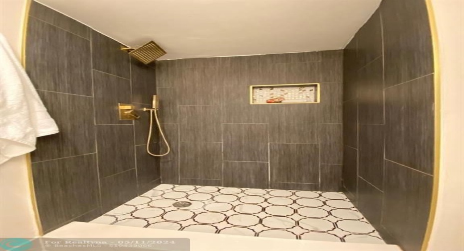 Walk in shower with gold fixtures