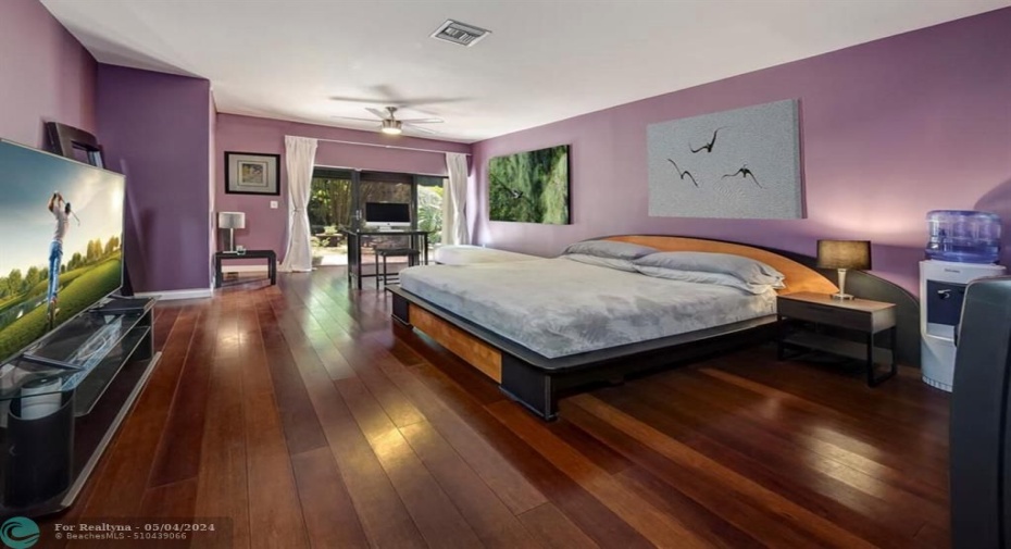 Master Bedroom with wood flooring and sitting area