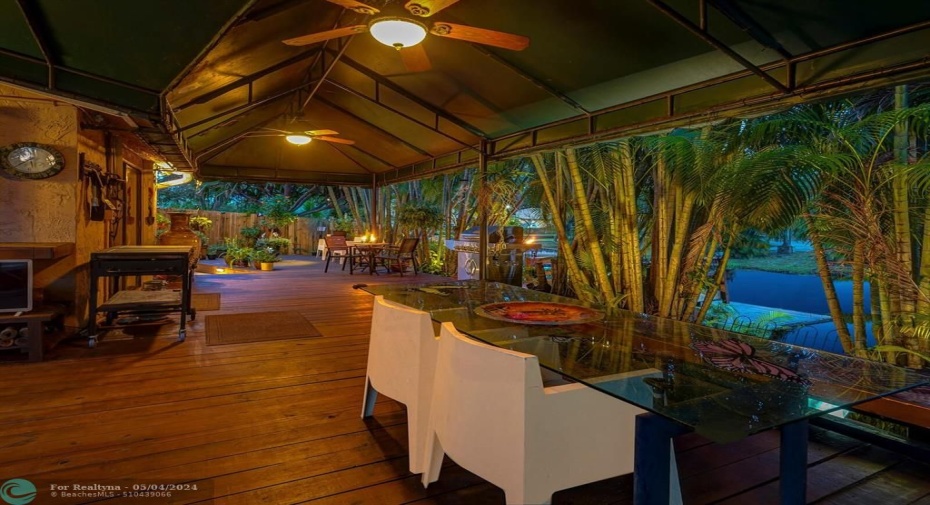 An entertainers delight with covered area, wood deck  and lots of palm trees