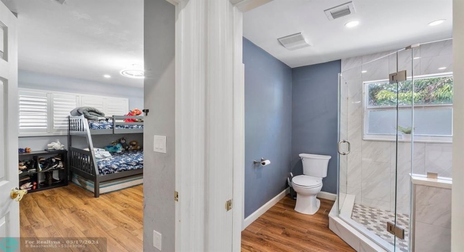 Bright and airy guest bath features frameless shower!