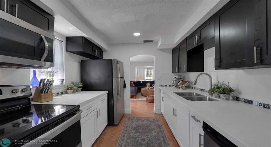 UPDATED GALLEY KITCHEN W/ MODERN WHITE QUARTZ COUNTERS AND BLACK & WHITE CUSTOM CABINETRY!