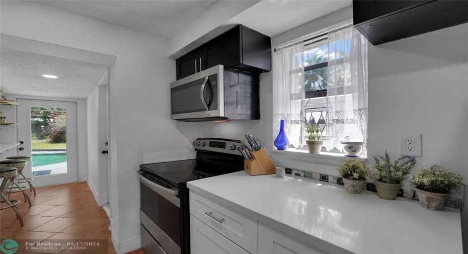 CUSTOM GALLEY KITCHEN W/ SS APPLIANCES AND MODERN WHITE QUARTZ COUNTERS!