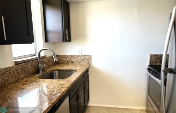 Granite and Stainless Steel Windowed Kitchen with custom Wood Cabinets