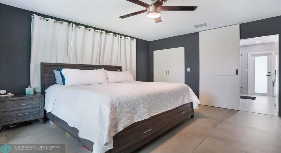The closet is behind the two white doors. The open doorway leads into the primary bathroom and is easily closed off by a sliding door.