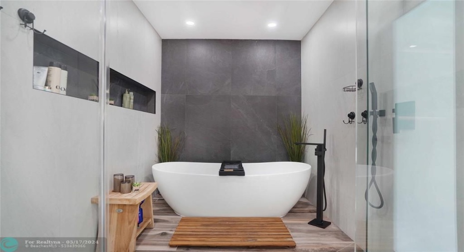 The spa tub, shower, and rainfall shower head are enclosed.