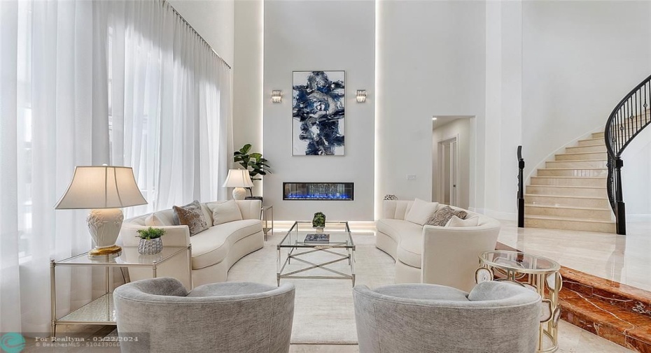 Close the sheer shades for a quiet reading or relaxing time with the remote controlled fireplace that can change to any color flame or any colored crystal base, Marble staircase & wrought iron circular banister,
