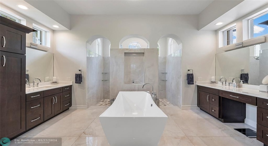 The master bathroom suite is a masterpiece and was remodeled in 2022 with modern soaking tub and multiple Moen shower jet system and Delta body jets on his and hers safari showers,This bathroom has its own 50 gallon water heater system so you can close the door and steam the entire bathroom with music on the speaker system and a glass of wine!