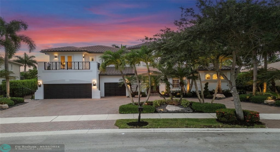 The front view of the Marshbrook extended model on a typical daily sunset view we get orange & purple skies nearly every evening in the community of Old Brook, The home has just been painted & remodeled in 2021 has a new roof (Tobacco to match the trim)Exterior landscape lighting + circular driveway with center island palm trees, Hurricane impact protection on all windows and doors,