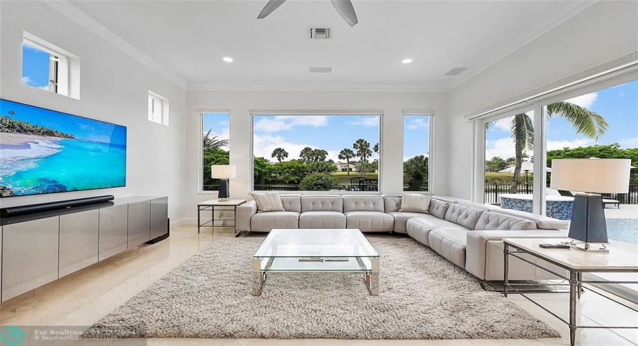 Lots of room for a large family to relax together in this huge family room with wide landscape windows and lots of sunshine