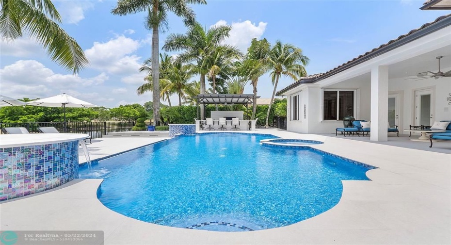 Daytime view of the pool & patio with lush landscaping