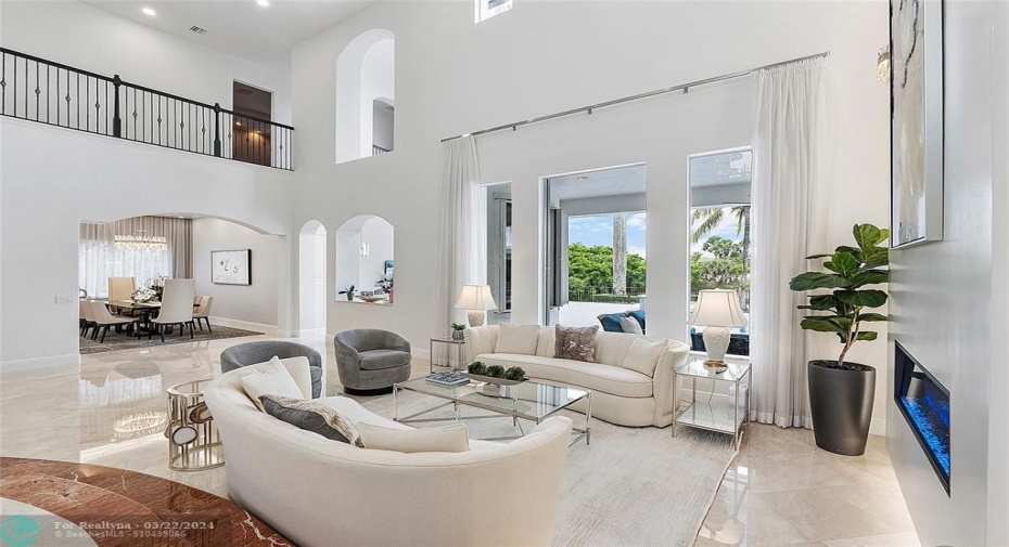 Step into the living room of tranquility, marble flooring & 2 story modern fireplace 23ft high, Custom window sheers are pretty open or closed,