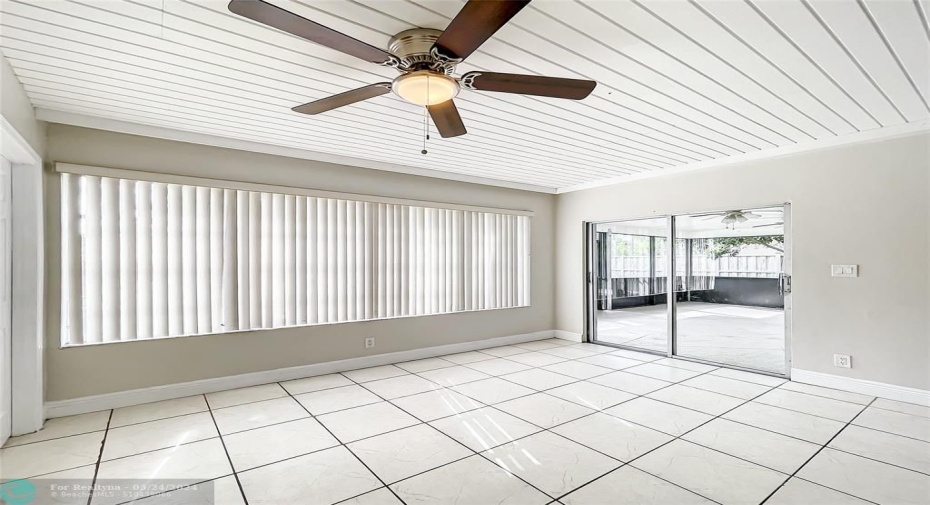 view from family room to huge screen patio under roof